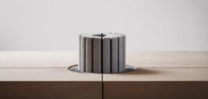 Fotorealistisk bild av en kärnprov från betong, borrad med diamantborrning, på en träyta. Minimalistisk design.